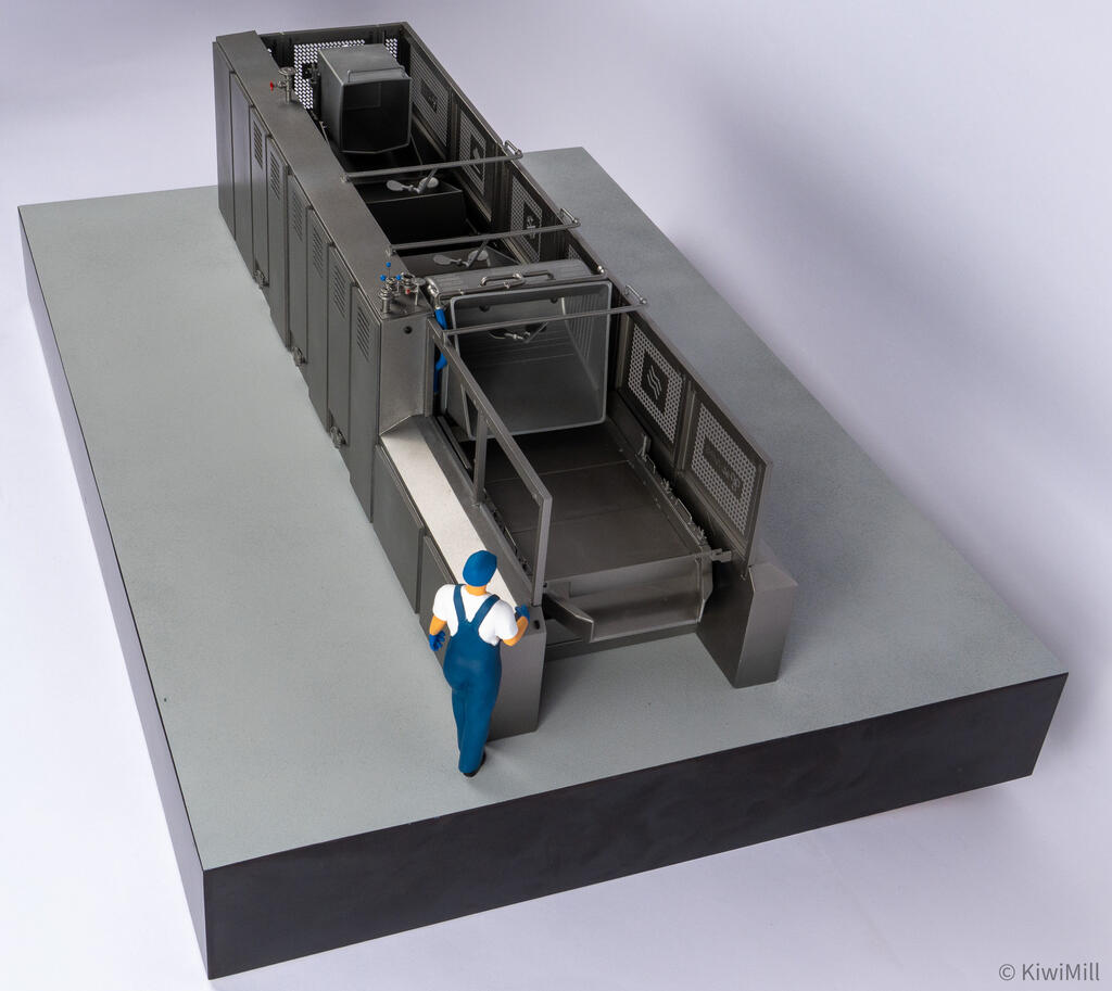 Cooking line model from the loading end, looking down the infeed with guard panels raised and a worker figure